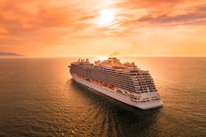 Navire de croisière blanc naviguant au coucher du soleil