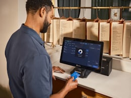 Passager réglant un achat par carte bancaire sur un terminal de paiement à un comptoir